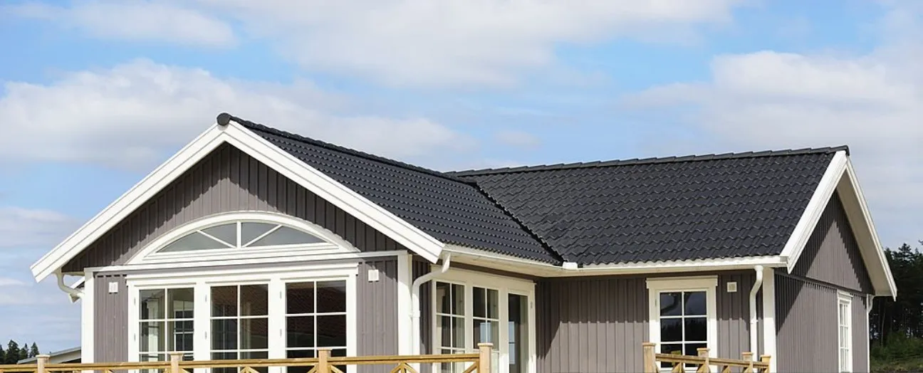 Nybyggt hus med svart tak och ljus fasad